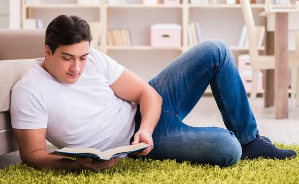 Hombre leyendo libro en casa en el suelo — Foto de Stock