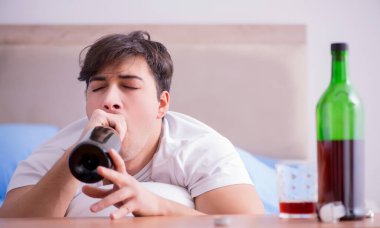Yatakta içen alkolik adam depresyona giriyor.