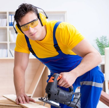 Tamirci marangoz bir seçimle tahta tahtayı kesiyor.