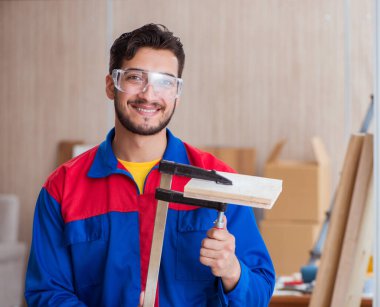 Klemplerle çalışan genç bir tamirci.