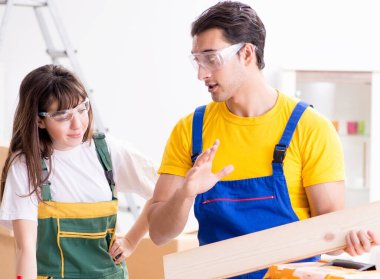 Ahşap atölyesinde kadın marangozluk ipuçlarını açıklayan adam