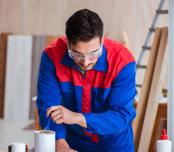 Yooung reparador carpinteiro trabalhando com pintura — Fotografia de Stock