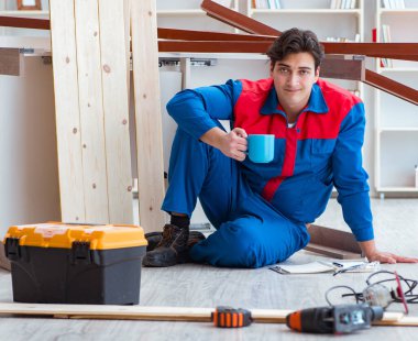 İnşaatta defter planlama yapan genç bir marangoz.