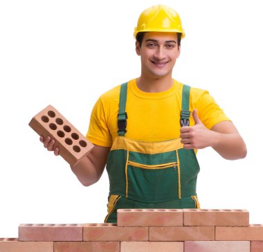 Yakışıklı inşaat işçisi tuğla duvar inşa ediyor.