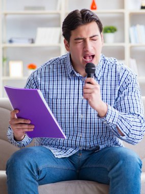 Evde karaoke yapan komik adam.