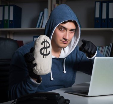 Genç hacker geceleri bilgisayarı hackliyor.