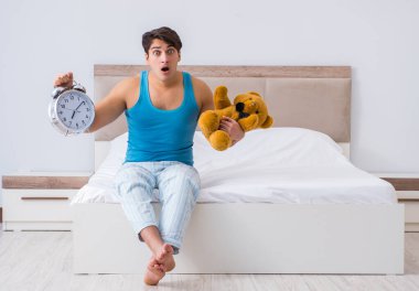 Genç adam yatakta uyanıyor.