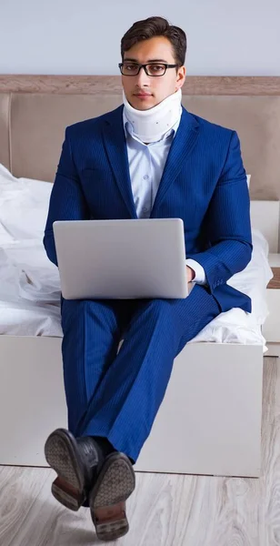 Businessman with neck injury working from home — Stock Photo, Image