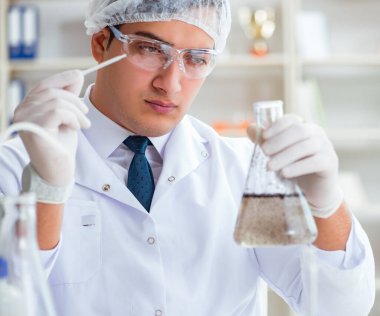 Genç araştırmacı bilim adamı bir su testi kirliliği araştırması yapıyor.