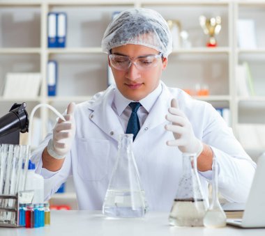 Genç araştırmacı bilim adamı bir su testi kirliliği araştırması yapıyor.