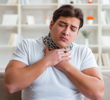 Genç adam boğaz ağrısı çekiyor.