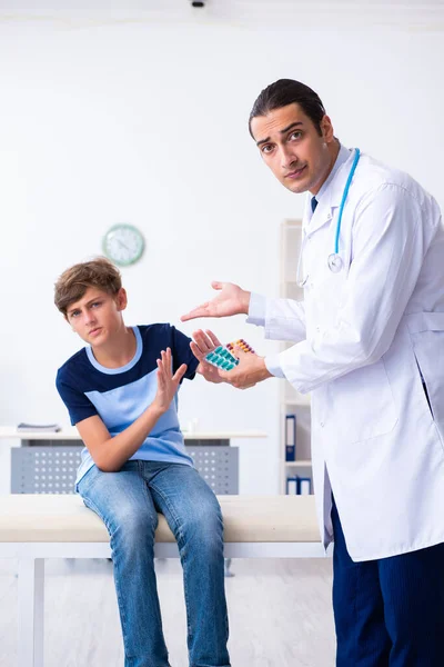 Молодой врач осматривает мальчика в клинике — стоковое фото