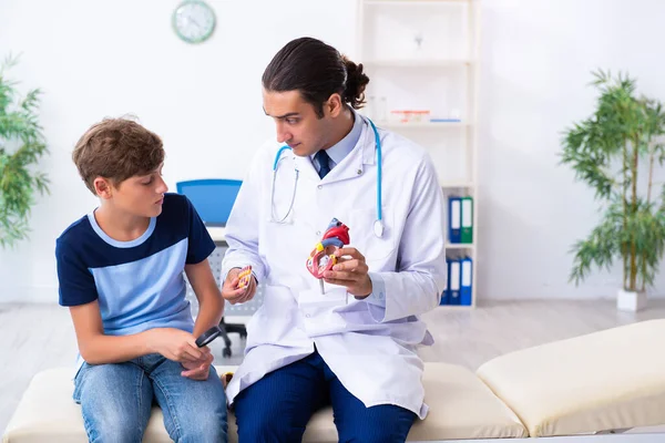 Joven médico examinando a un niño en la clínica —  Fotos de Stock