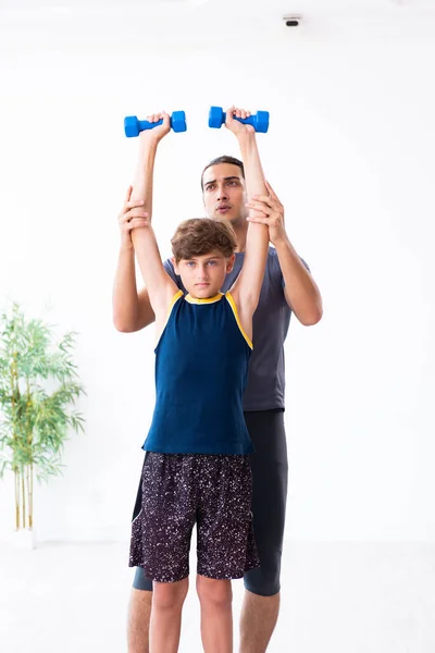 Genç baba ve oğlu egzersiz yapıyor. — Stok fotoğraf