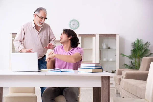 Alter Vater hilft seinem Sohn bei der Prüfungsvorbereitung — Stockfoto