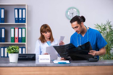 Hastanedeki resepsiyonda çalışan iki doktor.