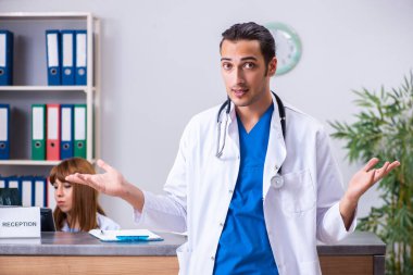 Hastanedeki resepsiyonda çalışan iki doktor.