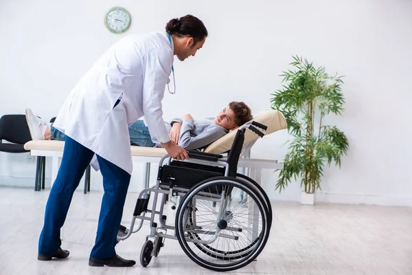 Young male doctor pediatrist and boy in wheel-chair — Stock Photo, Image