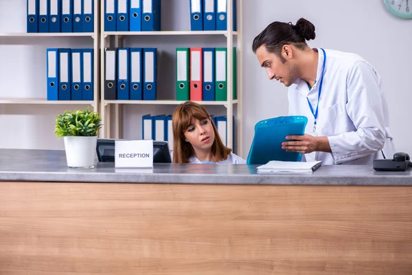 Two doctors working at the reception in the hospital — Stock Photo, Image