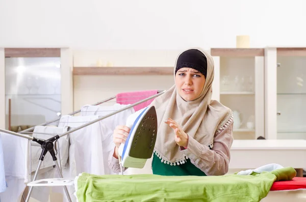 Frau im Hijab bügelt zu Hause Kleidung — Stockfoto