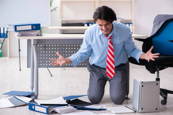 Joven empleado masculino infeliz con el trabajo excesivo — Foto de Stock