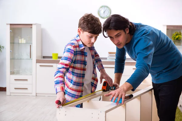 Jovem carpinteiro ensinando seu filho — Fotografia de Stock