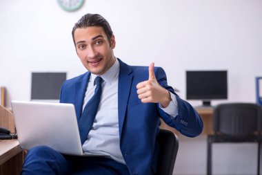 Genç yakışıklı işadamı ofiste çalışıyor.