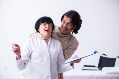 Yaşlı kadın psikiyatrist genç erkek hastayı ziyaret ediyor