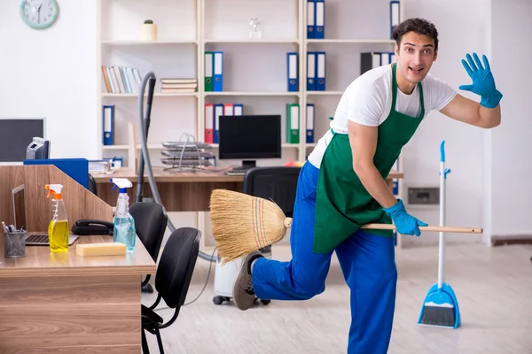 Fiatal jóképű vállalkozó takarítja az irodát — Stock Fotó