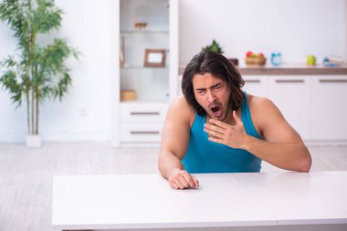 Genç adam evde uyanıyor.