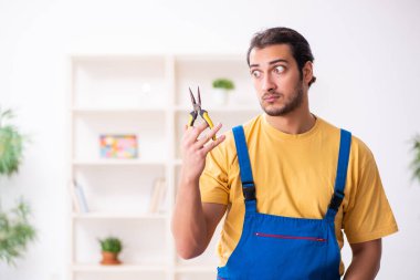 Genç erkek marangoz içeride çalışıyor.