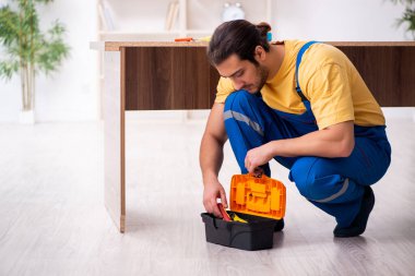 Genç erkek marangoz içeride çalışıyor.