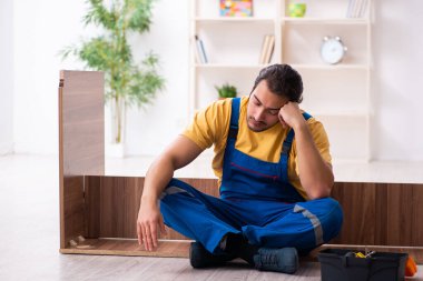 Genç erkek marangoz içeride çalışıyor.