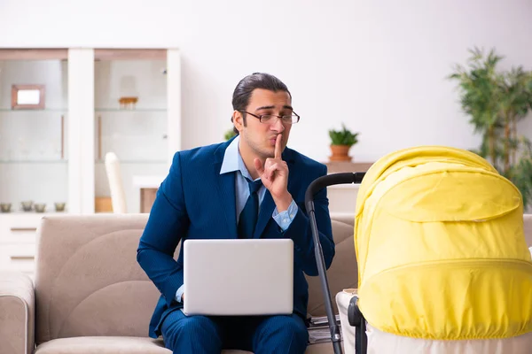 Young businessman looking after newborn at home