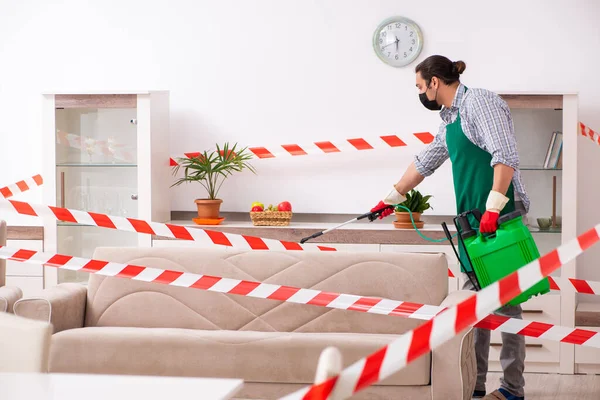 Young male sanitizer disinfecting indoors — Stock Photo, Image