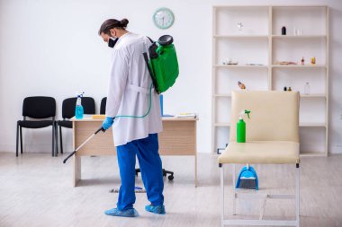 Genç erkek müteahhit salgın konseptinde dezenfekte kliniği