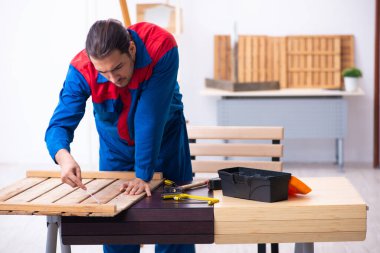 Genç erkek müteahhit atölyede çalışıyor.