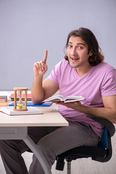 Young male student in the classroom at time management concept — Stock Photo, Image