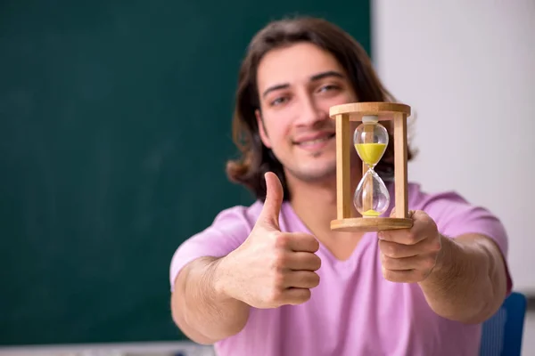 Jovem estudante do sexo masculino em sala de aula no conceito de gestão de tempo — Fotografia de Stock