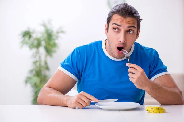 Молодой голодный человек в концепции диеты — стоковое фото