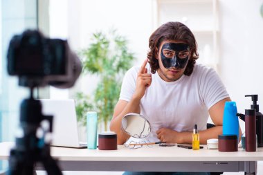 Genç erkek kozmetikçi blogu için video kaydediyor.