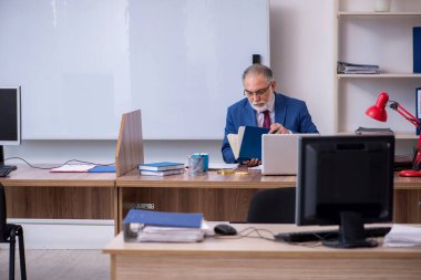 Ofiste çalışan yaşlı bir patron.