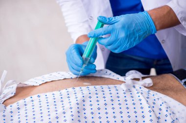 Yaşlı adam genç erkek stajyer doktoru ziyaret ediyor.