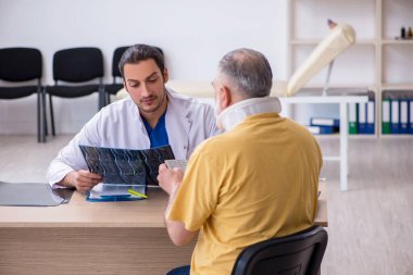 Yaşlı boyun yaralanması genç erkek doktor radyolojisti ziyaret ediyor.