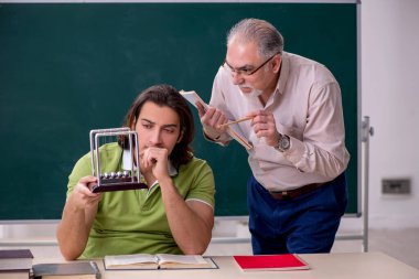 Yaşlı profesör fizikçi ve genç öğrenci sınıfta.