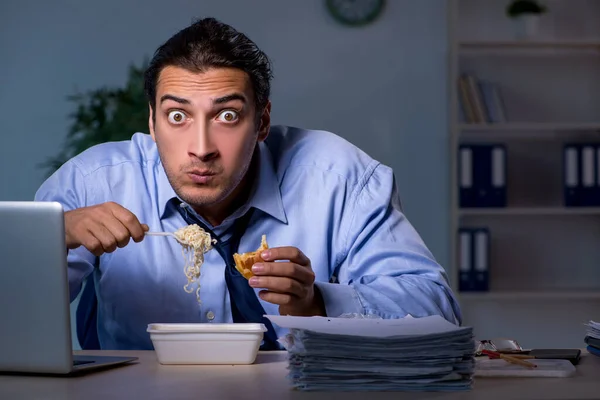 Funcionário com fome trabalhando até tarde no escritório — Fotografia de Stock