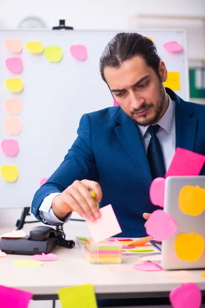 Joven empleado masculino en concepto de prioridades contradictorias — Foto de Stock