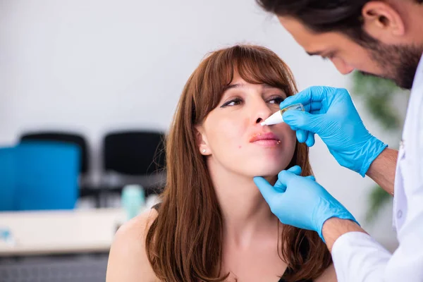 Mladá žena návštěva mužského lékaře dermatolog — Stock fotografie