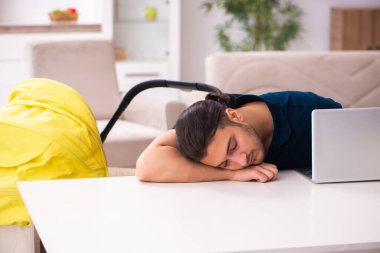 Genç baba yeni doğan bebeğe bakıyor.