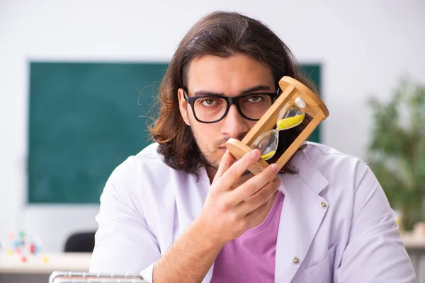 Jonge mannelijke fysicus leraar in tijdmanagement concept — Stockfoto